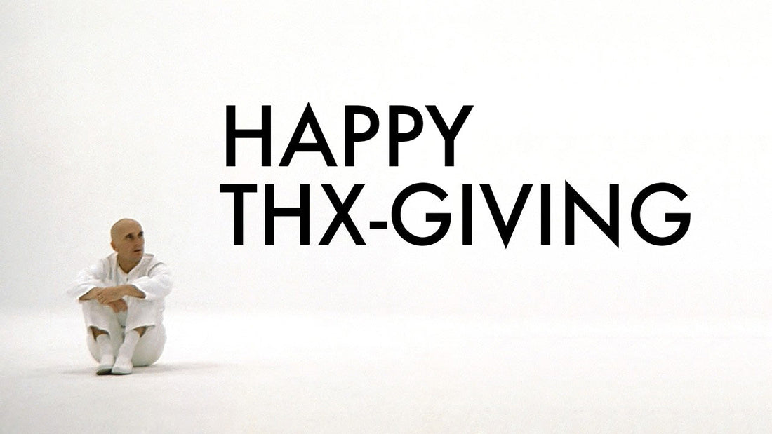 Robert Duvall in a white outfit sitting on a white background from the film THX-1138, with 'Happy THX-GIVING' text.