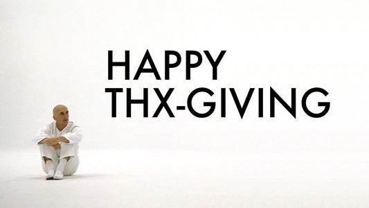 Robert Duvall in a white outfit sitting on a white background from the film THX-1138, with 'Happy THX-GIVING' text.